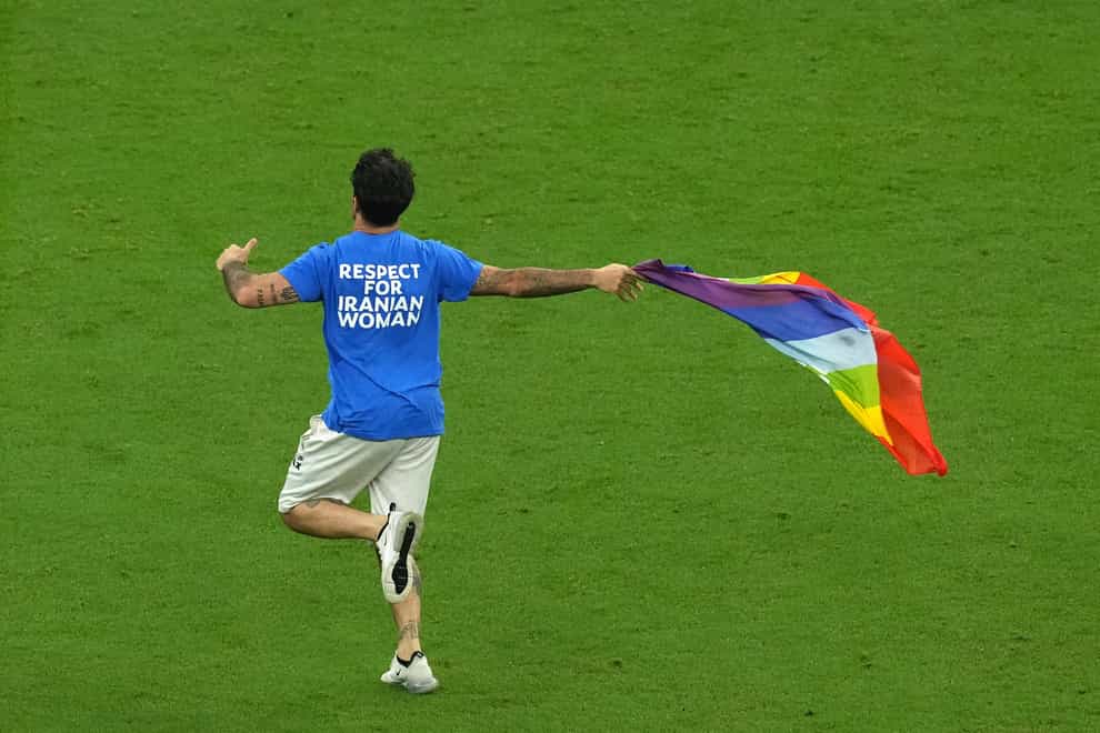 Mario Ferri waves a rainbow flag as he invades the pitch during the FIFA World Cup Group H match at the Lusail Stadium in Lusail, Qatar (Martin Rickett/PA)