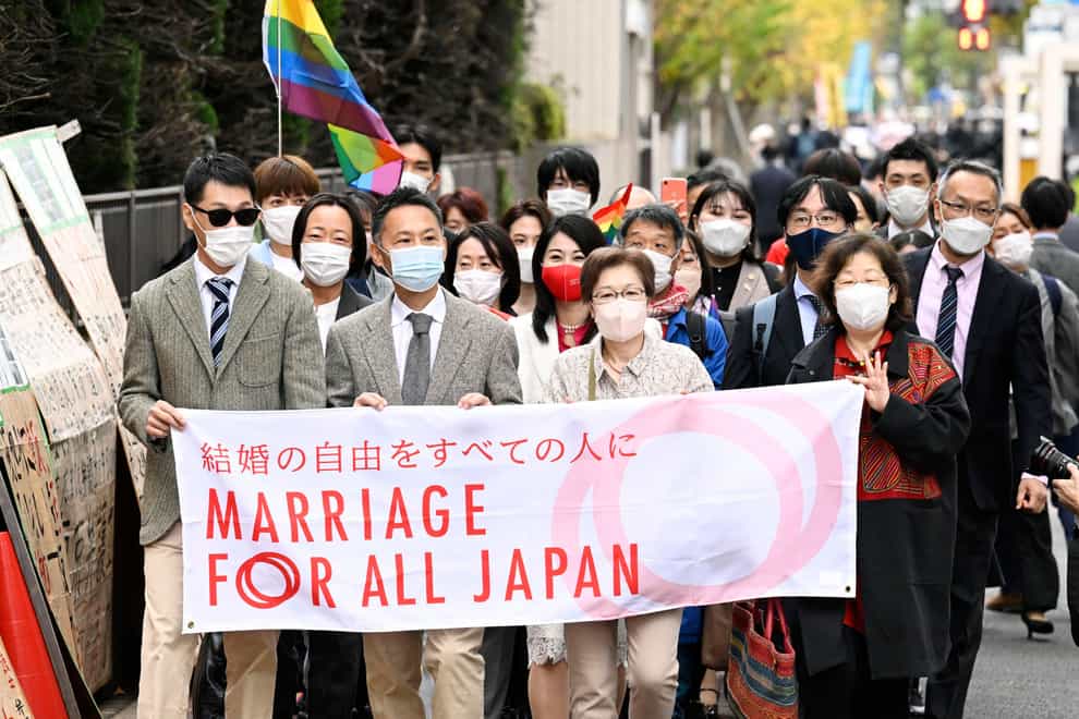 Plaintiffs and supporters walk to the Tokyo district court (Kyodo News via AP)
