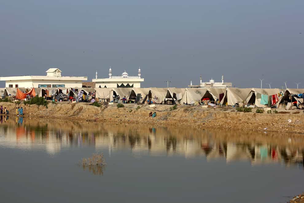 People take refuge in a relief camp set up on a higher ground surrounded by floodwaters in Pakistan (Fareed Khan/AP)