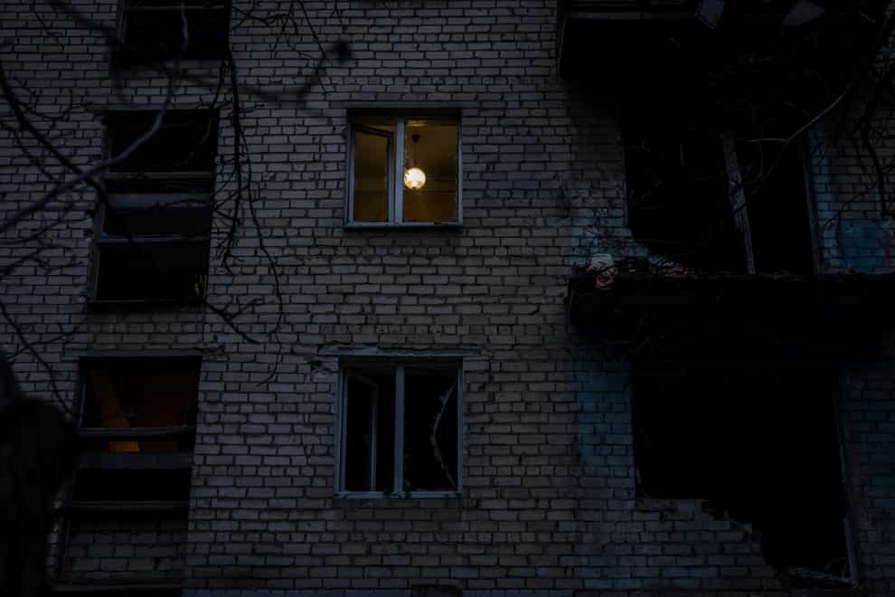 A lamp illuminates a room of a recently damaged building during a Russian strike in the southern city of Kherson, Ukraine, Sunday, Nov. 27, 2022. Shelling by Russian forces struck several areas in eastern and southern Ukraine overnight as utility crews continued a scramble to restore power, water and heating following widespread strikes in recent weeks, officials said Sunday. (AP Photo/Bernat Armangue)