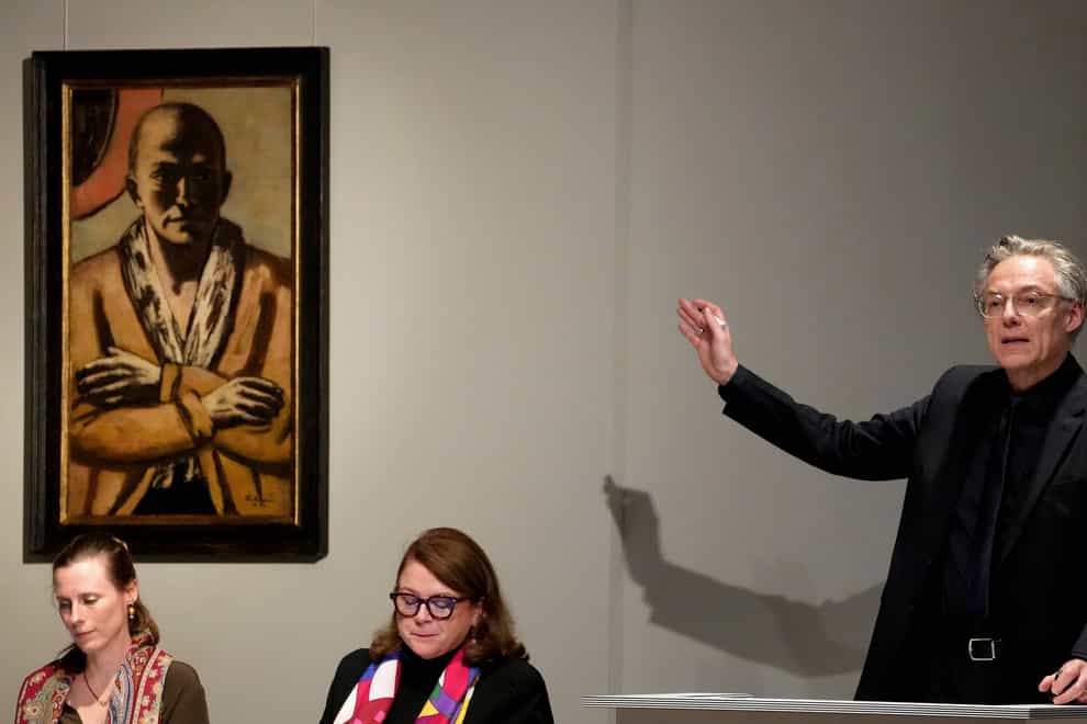 Auctioneer Markus Krause gestures in front of the painting ‘Selbstbildnis gelb-rosa’ (self-portrait yellow-rose), 1943 oil on canvas, by German painter Max Beckmann, as it is auctioned in Berlin, Germany, Thursday, Dec. 1, 2022. A self-portrait painted during World War II by German expressionist artist Max Beckmann has been sold in Berlin for 20 million euros ($20.7 million), which appears to be a record for an art auction in Germany. (AP Photo/Michael Sohn)