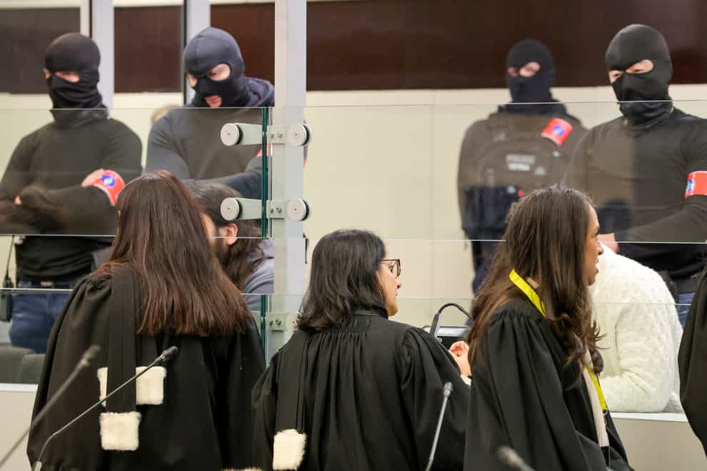 Lawyers speak with defendants through the glass of a specially designed box at the start of the trial of 10 people over terror attacks in Brussels in March 2016 (Olivier Matthys/AP)