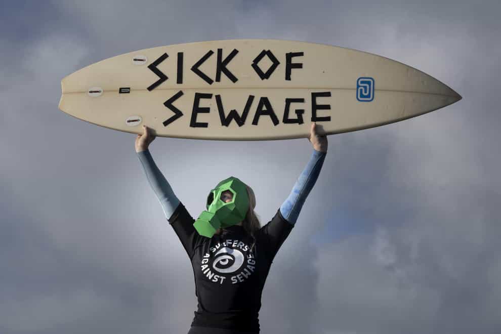 A representative from Surfers against Sewage protests against sewage discharges at an overflow pipe on Long Rock Beach in Penzance, Cornwall, to coincide with the publication of The 2022 Water Quality report.