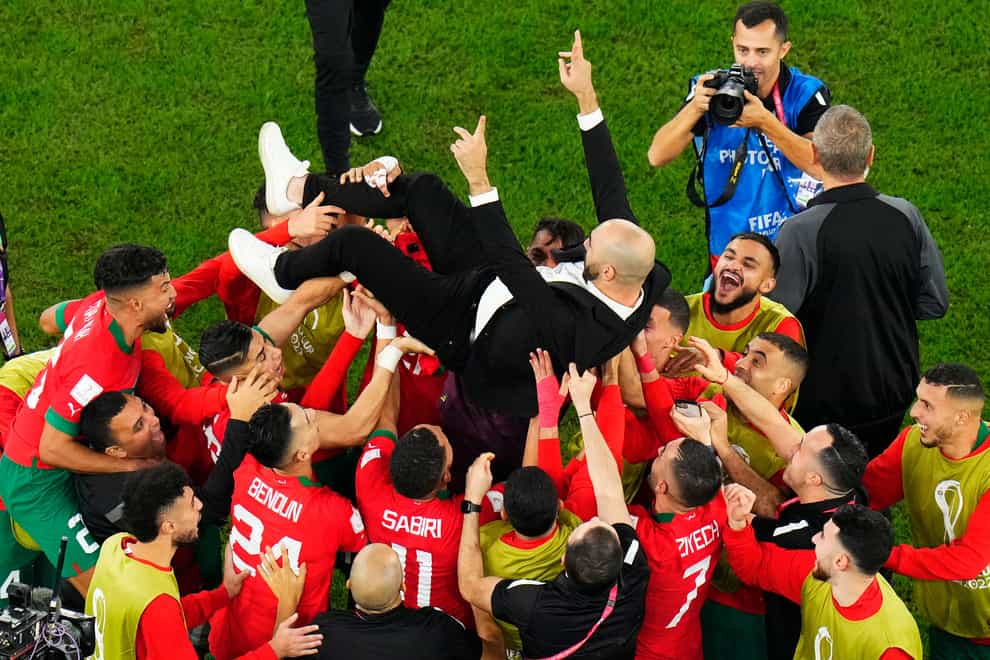 Morocco head coach Walid Regragui is held aloft by his players after their upset win over Spain (Petr David Josek/AP)