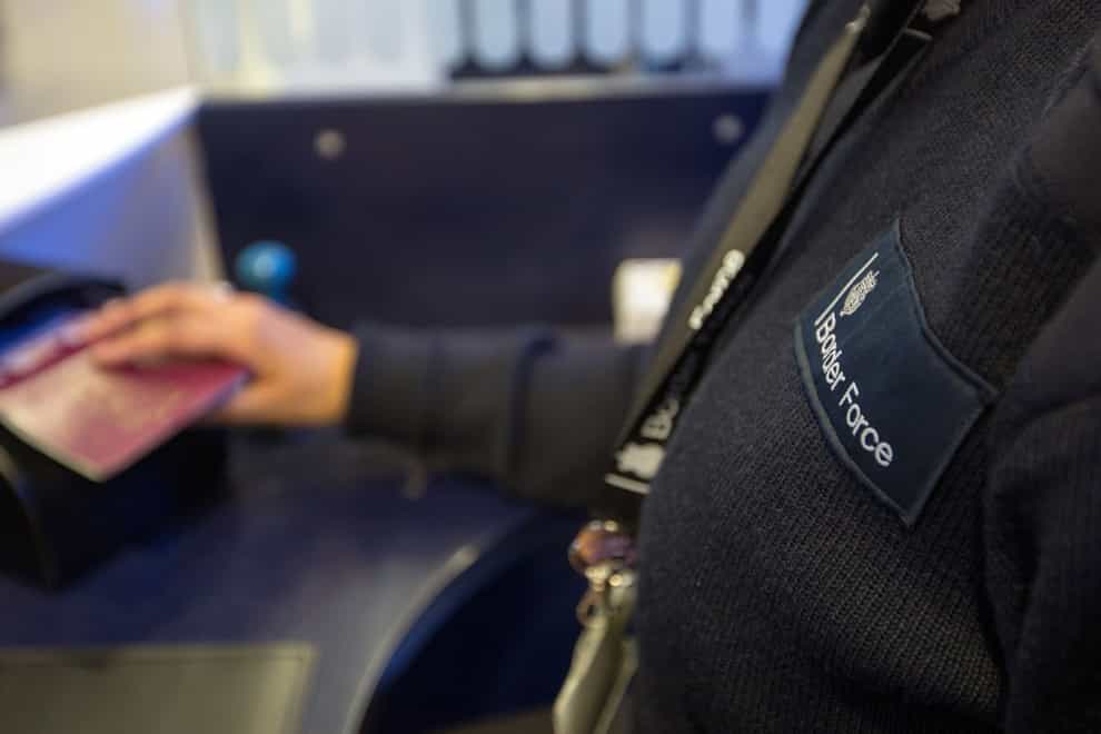 A Border Force officer checks passports (Steve Parsons/PA)