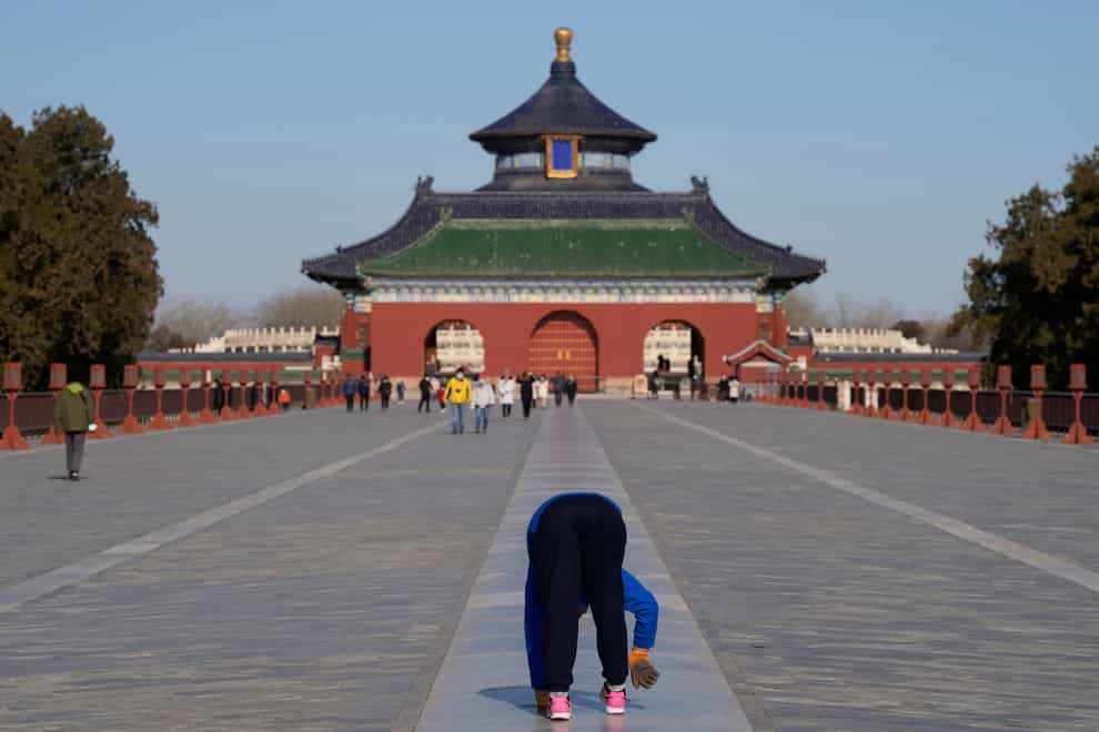 A man walks on all four limbs as a form of exercise in the Temple of Heaven park in Beijing (Ng Han Guan/AP)