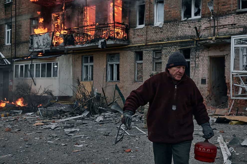A local resident leaves his home after Russian shelling destroyed an apartment house in Bakhmut, Donetsk region, Ukraine (LIBKOS/AP)