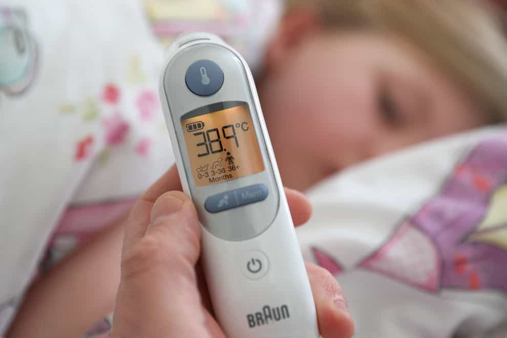 A temperature of 38.9 degrees is visible on a digital ear thermometer after being taken from a poorly child (PA)