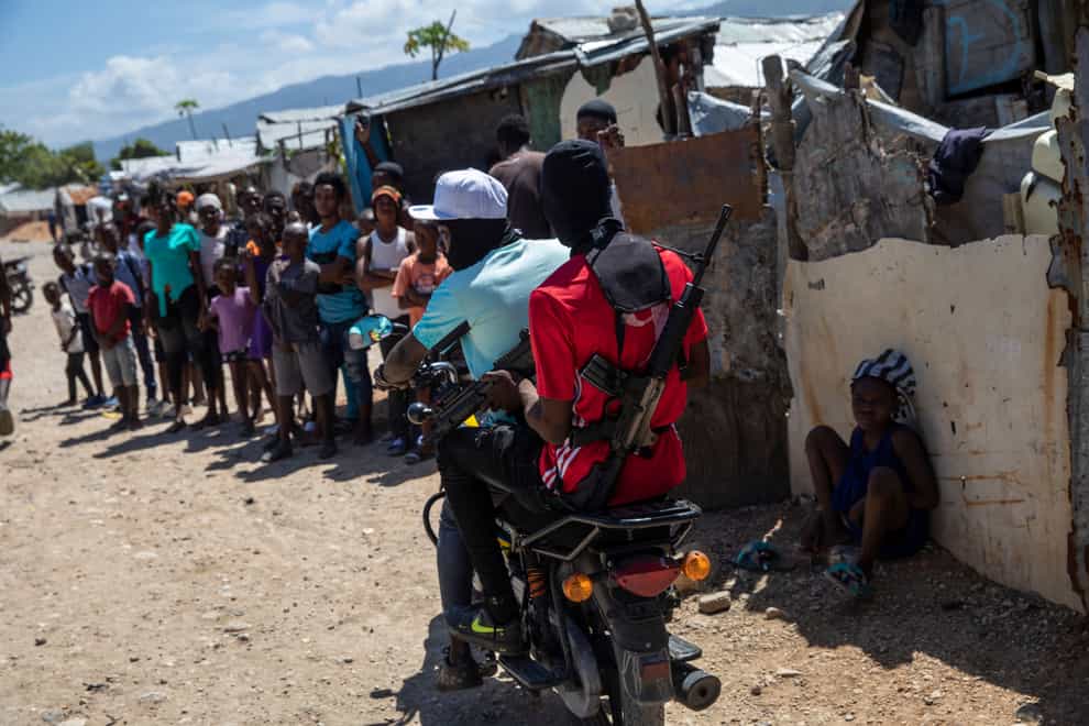 G9 coalition gang members ride a motorcycle through the Wharf Jeremy street market in Port-au-Prince (AP)