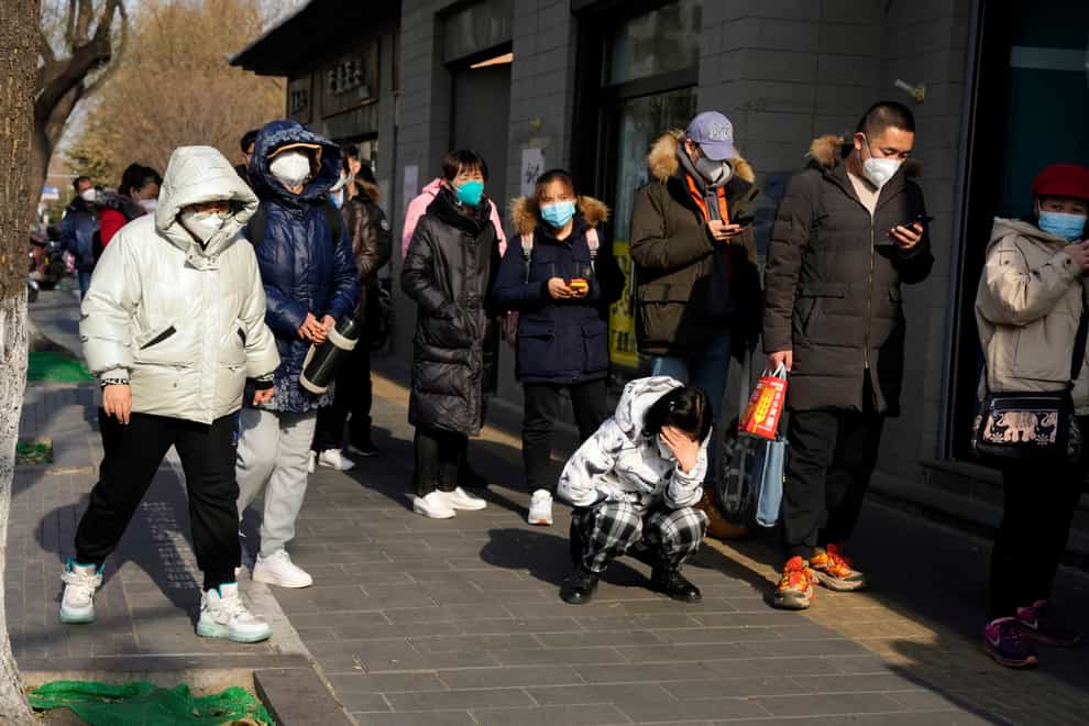 Residents line up for medicine at a pharmacy in Beijing (AP)