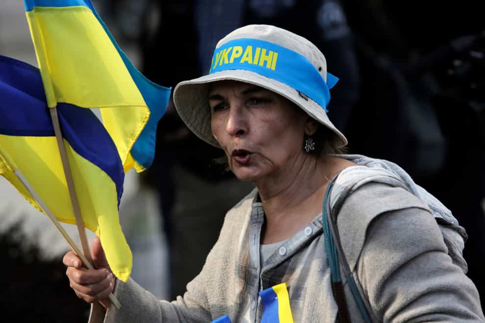A Ukrainian supporter shouts slogans as she holds Ukrainian flags in front of Bulgarian Parliament in Sofia, Bulgaria (Valentina Petrova/AP/PA)
