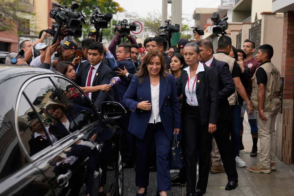 Peru’s new President Dina Boluarte walks to her car after speaking to the press as she leaves her home in Lima, Peru (Martin Mejia/AP/PA)