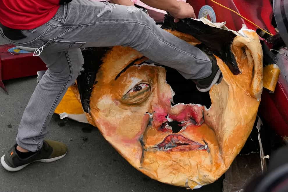 A protester kicks an effigy of Philippine President Ferdinand Marcos Jr (AP)
