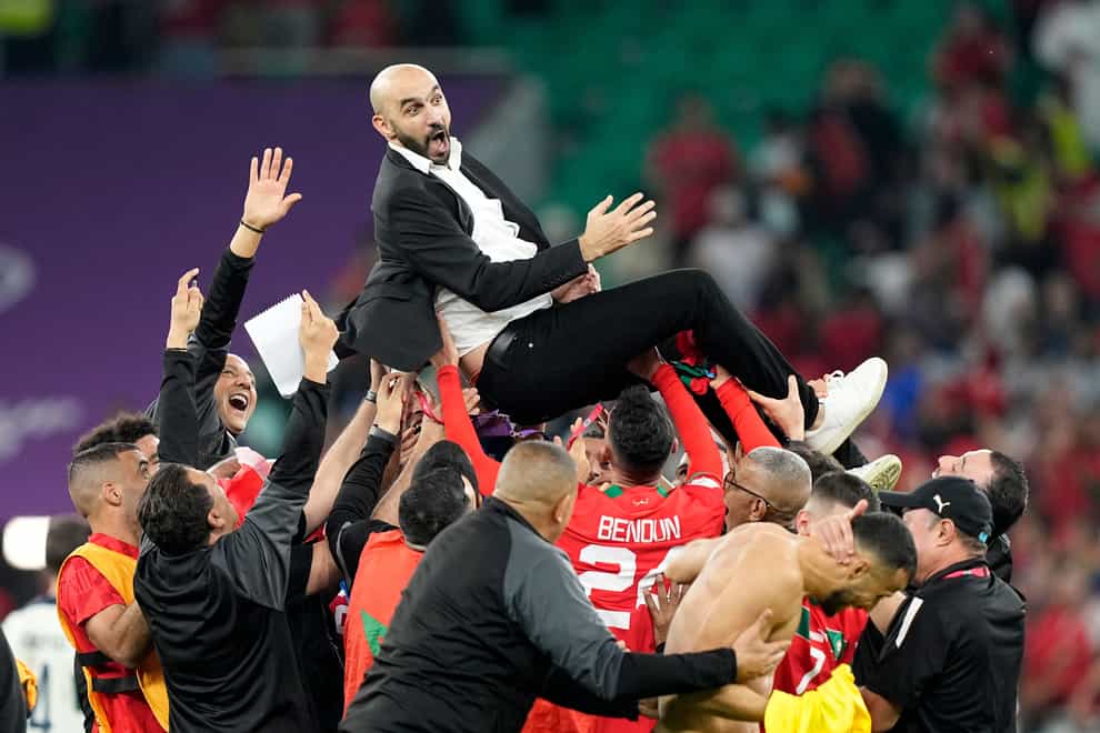 Morocco boss Walid Regragui is held aloft by his players (Martin Meissner/AP)