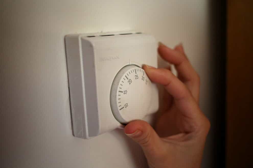 A person using a central heating thermostat (Steve Parsons/PA)