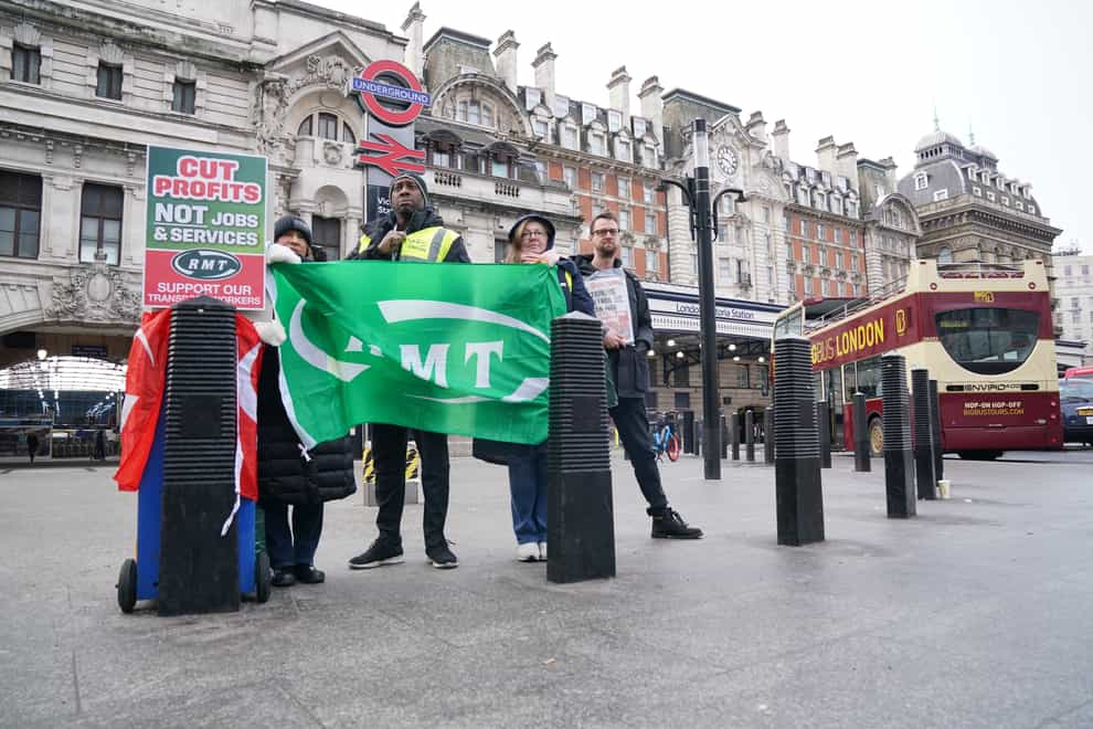 Members of the Rail, Maritime and Transport union stand on the picket line outside Victoria station in central London (Jonathan Brady/PA)
