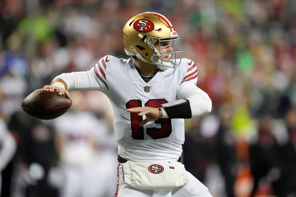 Brock Purdy threw for two touchdowns as the San Francisco 49ers defeated the Seattle Seahawks 21-13, claiming the NFC West in the process (Stephen Brashear/AP)