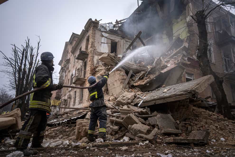 Firefighters extinguish a fire at the building which was destroyed by a Russian attack in Kryvyi Rih (Evgeniy Maloletka/AP)