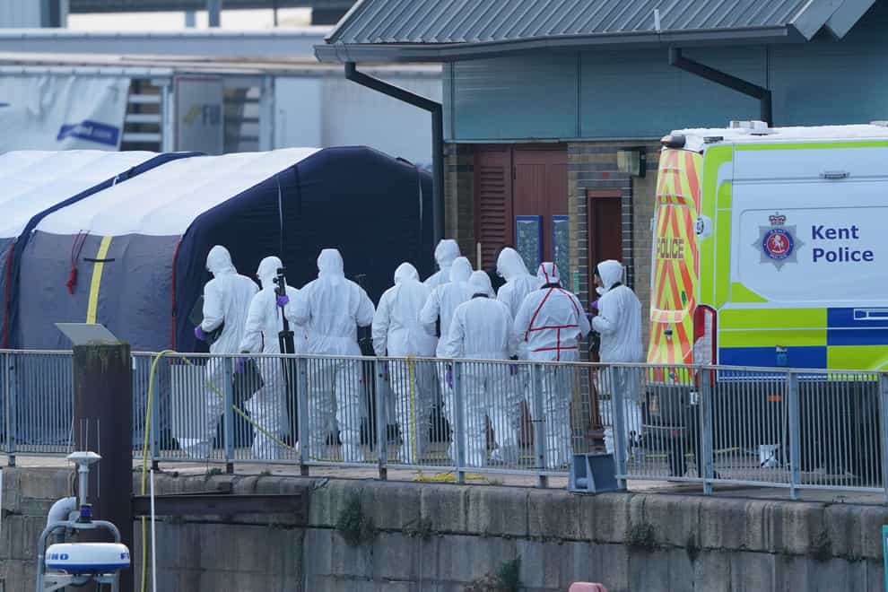 Police officers head to the forensic tents erected at the RNLI station at the Port of Dover after a large search and rescue operation launched in the Channel (PA)