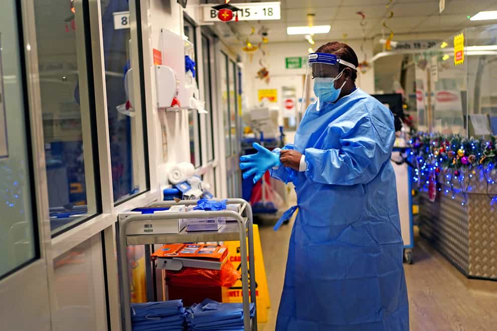 A nurse puts on PPE in a ward for covid patients at King’s College Hospital, in south east London (PA)