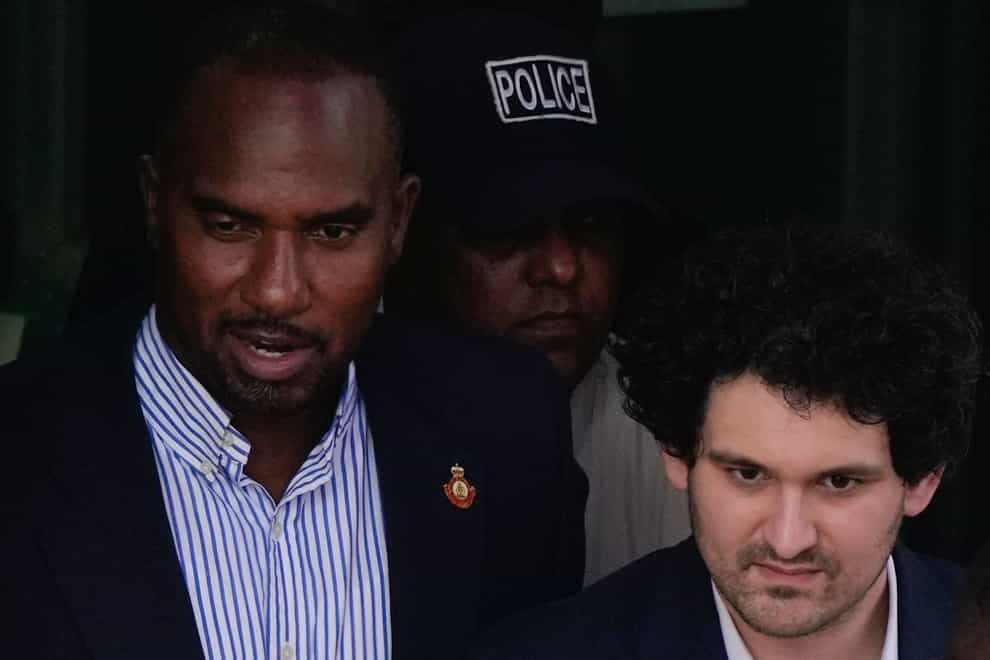 FTX founder Sam Bankman-Fried, right, is escorted out of Magistrate Court toward a Corrections van, following a hearing in Nassau, Bahamas, on Monday, December 19, 2022 (Rebecca Blackwell/AP/PA)