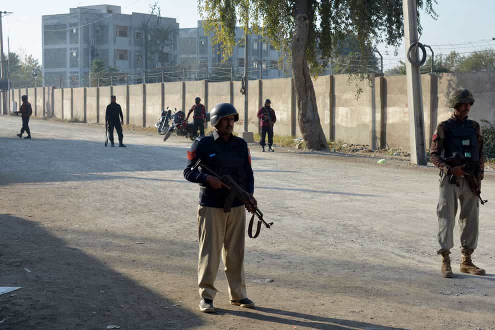 Security officials guard a blocked road leading to a counter-terrorism centre (Muhammad Hasib/AP)