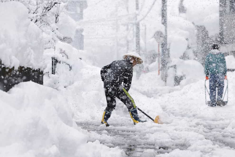 Residents remove snow during heavy snow in Nagaoka, Niigata prefecture, northern Japan, on Monday (Kyodo News/AP)