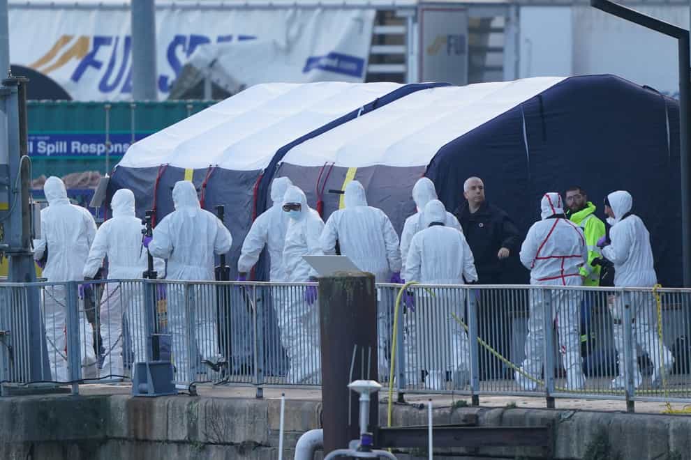 Police Forensic officers head to the forensic tents erected at the RNLI station at the Port of Dover after a large search and rescue operation launched in the Channel off the coast of Dungeness, in Kent, following an incident involving a small boat (Gareth Fuller/PA)