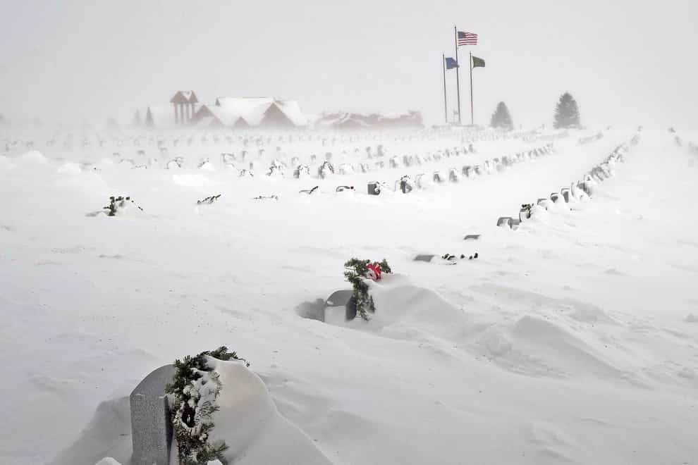Rows of headstones at the North Dakota Veterans’ Cemetery are blanketed by drifting snow (Tom Stromme/The Bismarck Tribune via AP)