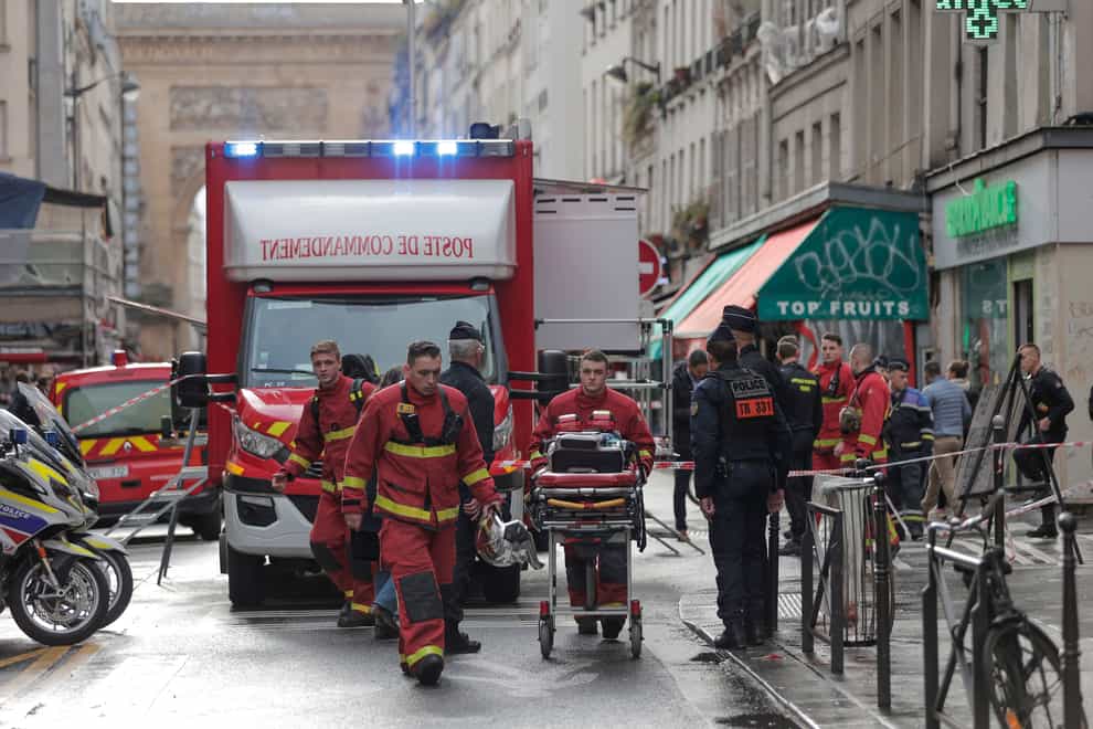 Fire brigade medics work on the scene where a shooting took place in Paris (AP)