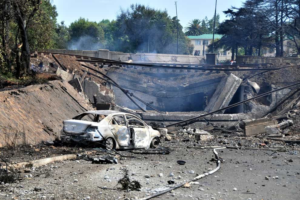 A burned out vehicle marks the spot where a gas tanker exploded under a bridge in Boksburg, east of Johannesburg on Saturday, December 24, 2022 (Hein Kaiser/AP/PA)
