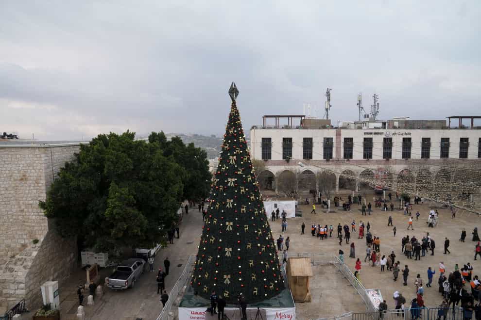 People gather in Manger Square, adjacent to the Church of the Nativity, traditionally believed to be the birthplace of Jesus Christ, in the West Bank town of Bethlehem on Saturday, December 24, 2022 (Mahmoud Illean/AP/PA)