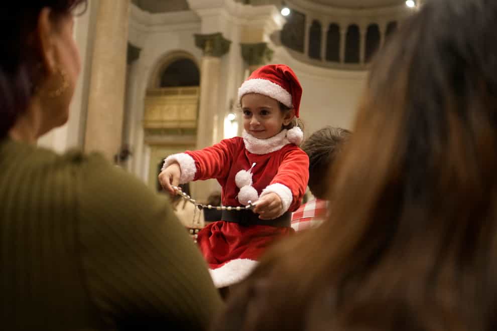 Egyptian Donciel Maykel Nasr, dressed in a Santa Claus outfit, attends Christmas Eve Mass at Saint Joseph’s Catholic Church in Cairo (Amr Nabil/AP)