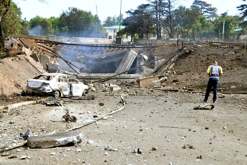 A burned-out vehicle marks the spot where a gas tanker exploded under a bridge (Hein Kaiser/AP)