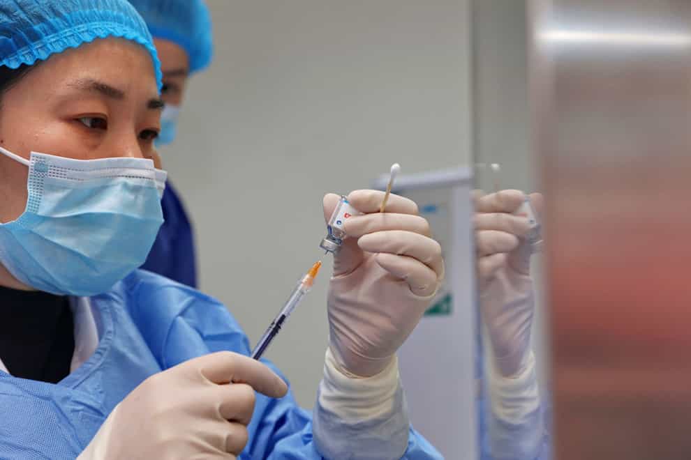 Chinese authorities are going door to door and paying people over 60 to have a coronavirus vaccination but, despite a surge in cases, many are alarmed by reports of side-effects (Chinatopix/AP)