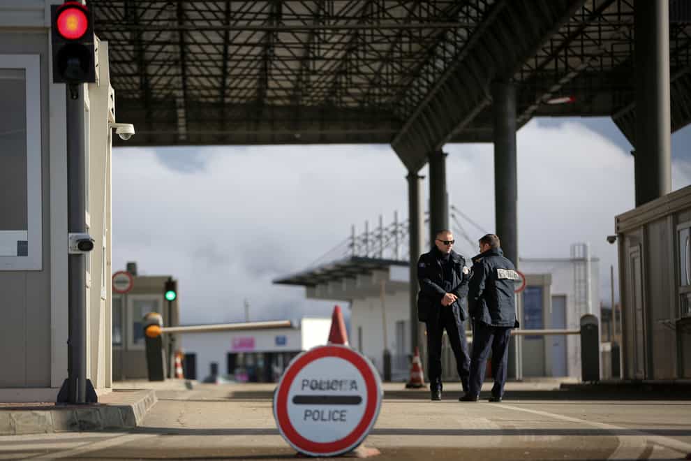 Kosovo police officers stand at the closed Merdare border crossing between Kosovo and Serbia on December 28, 2022 (Visar Kryeziu/AP/PA)
