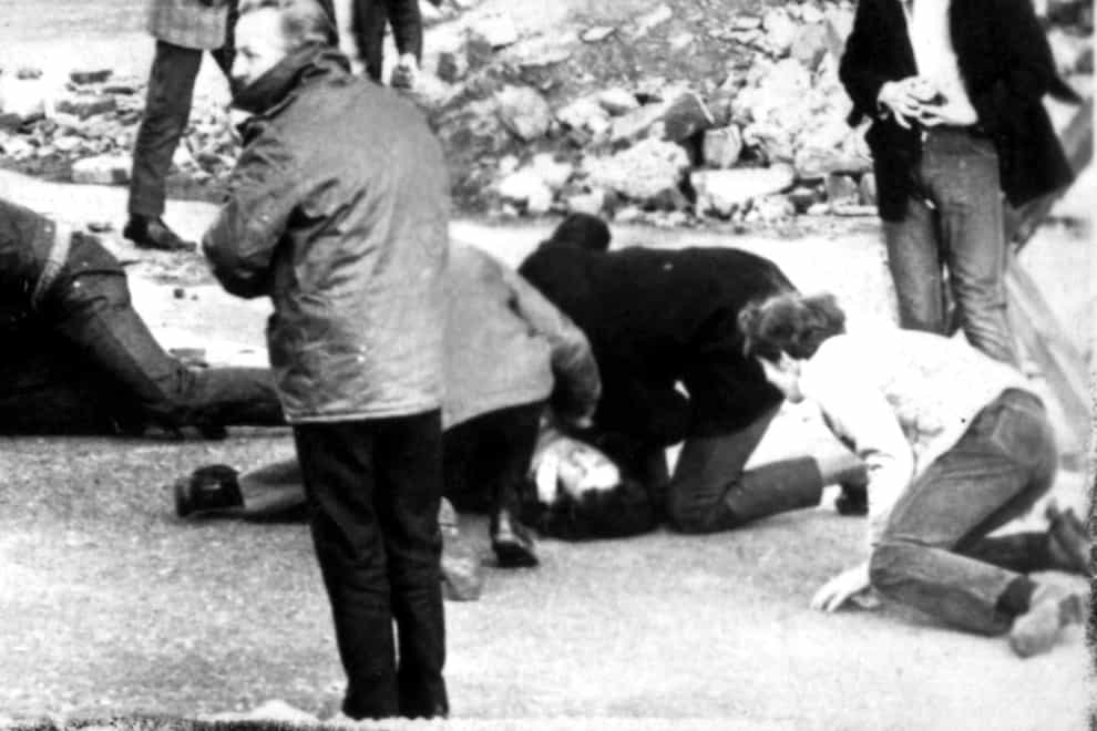 A man receiving attention during the shooting incident in Londonderry, Northern Ireland, which became known as Bloody Sunday (PA)