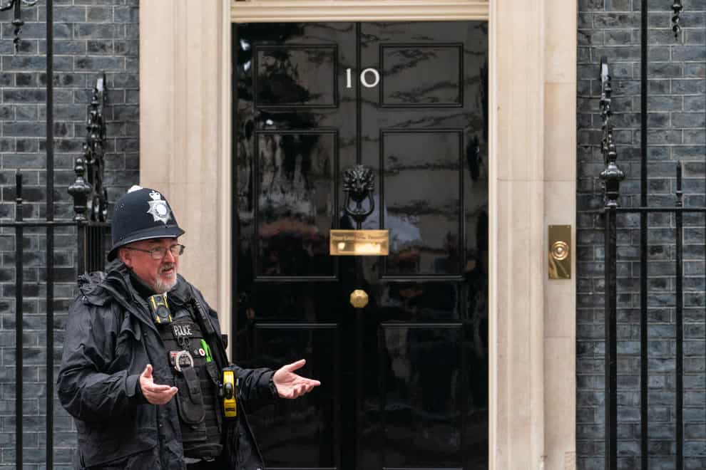 A police officer gestures to colleagues outside 10 Downing Street in Westminster, London (Dominic Lipinski/PA)