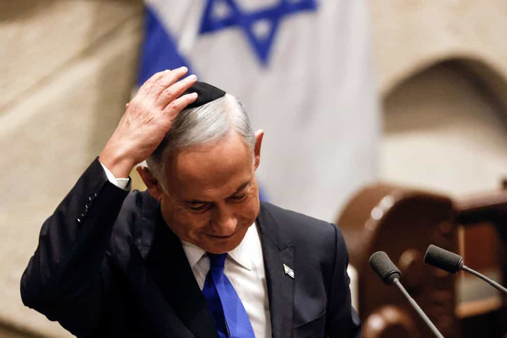 Benjamin Netanyahu adjusts his skull cap after speaking at a special session of the Knesset, Israel’s parliament, to approve and swear in a new government (Amir Cohen/Pool/AP)