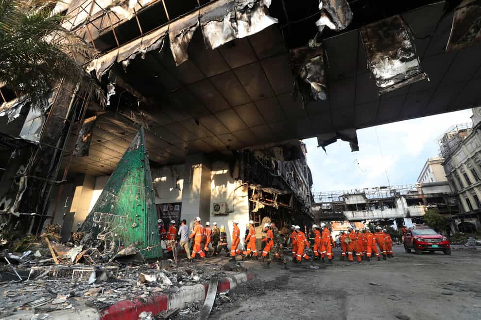 Cambodian and Thai rescue experts walk through a ruined building for a searching operation at the scene of a massive fire at a Cambodian hotel casino in Poipet, west of Phnom Penh, Cambodia (Heng Sinith/AP/PA)