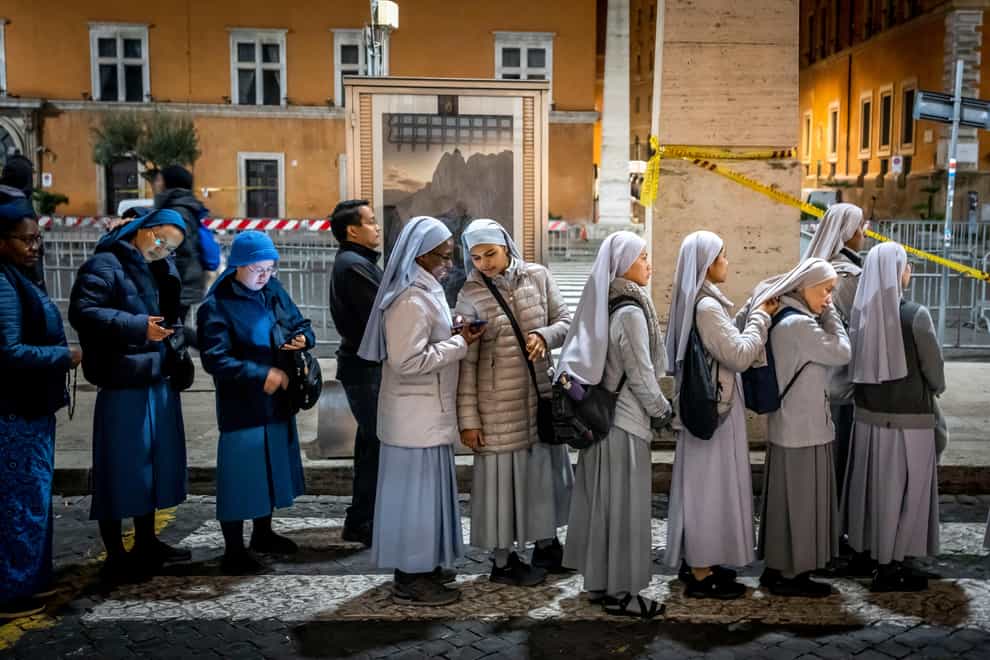 Nuns queue before dawn to view the body of Pope Emeritus Benedict XVI as it lies in state in St. Peter’s Basilica at the Vatican, Tuesday, Jan. 3, 2023. The Vatican announced that Pope Benedict died on Dec. 31, 2022, at 95, and that his funeral will be held on Thursday, Jan. 5, 2023. (AP Photo/Ben Curtis)
