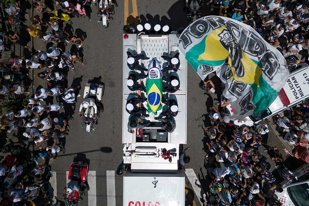Pele’s coffin draped in Brazil and Santos flags for his funeral procession (Matias Delacroix/AP)