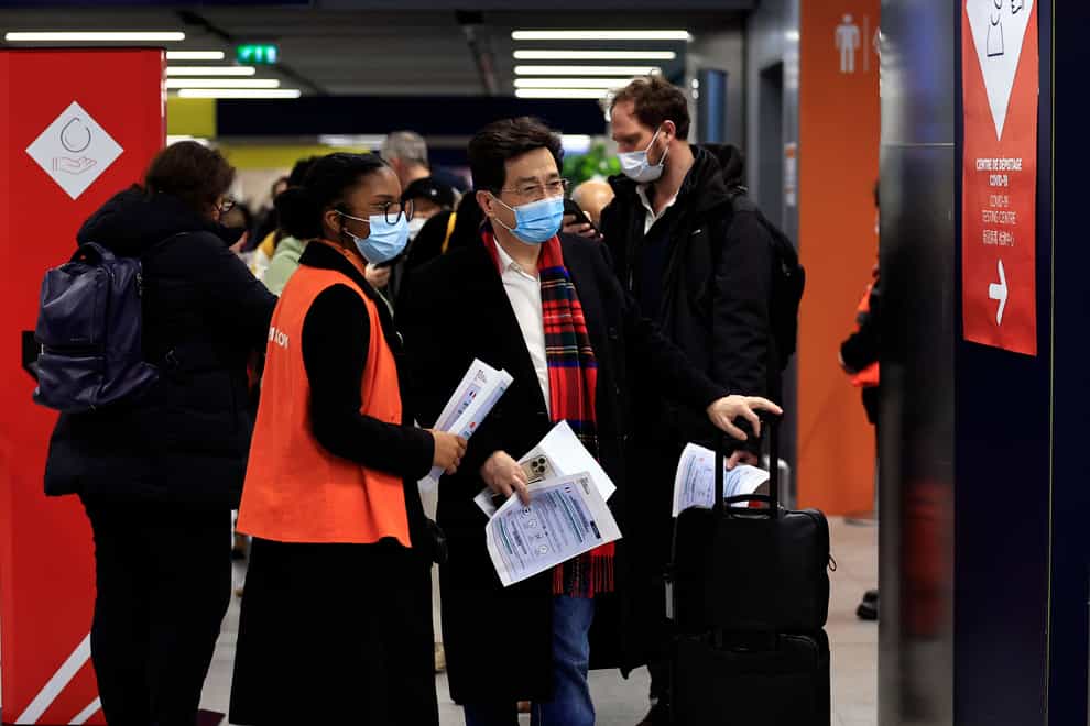 Passengers arriving from China wait in front of a Covid-19 testing area at the Roissy Charles de Gaulle airport, north of Paris (Aurelien Morissard/AP)