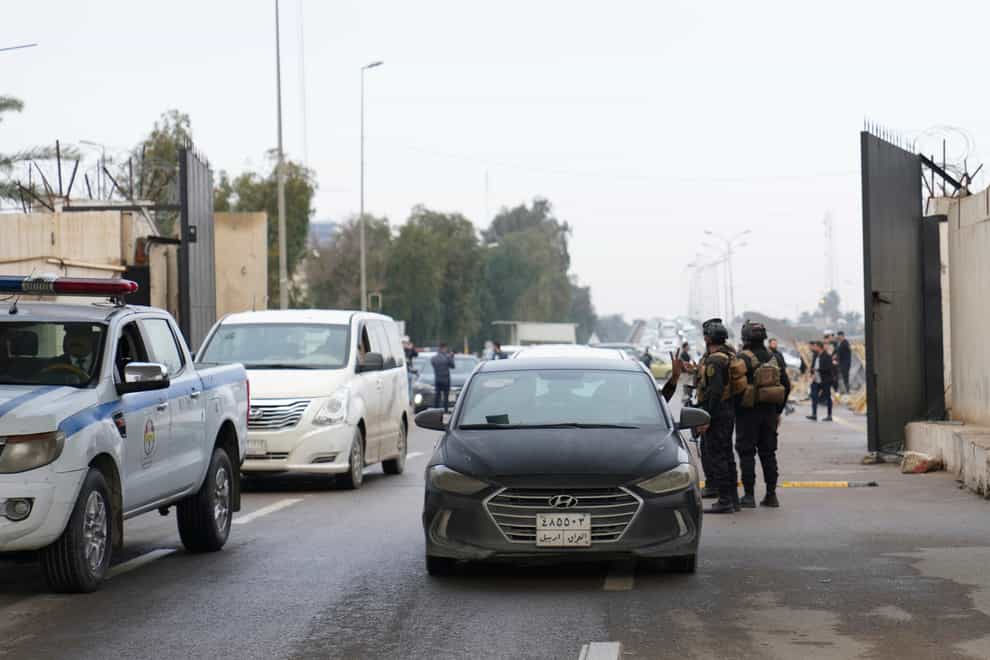 Iraqi security forces stand guard as they check motorists entering the Green Zone in Baghdad (Hadi Mizban/AP)