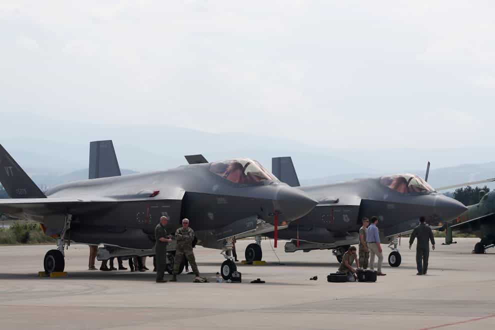 US military personnel work near F-35 fighter jet of the Vermont Air National Guard, parked in the military base at Skopje Airport, North Macedonia, on June 17 2022 (Boris Grdanoski/AP)