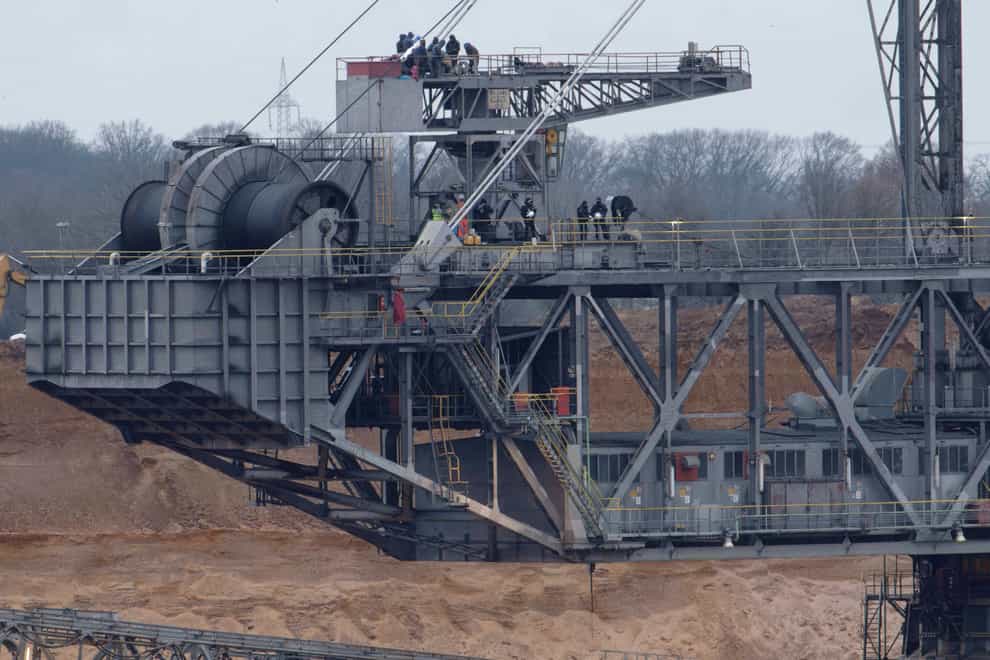 Climate activists are pictured on top of a bucket-wheel digger at the Hambach opencast lignite mine at Gelsdorf, Germany (dpa via AP)