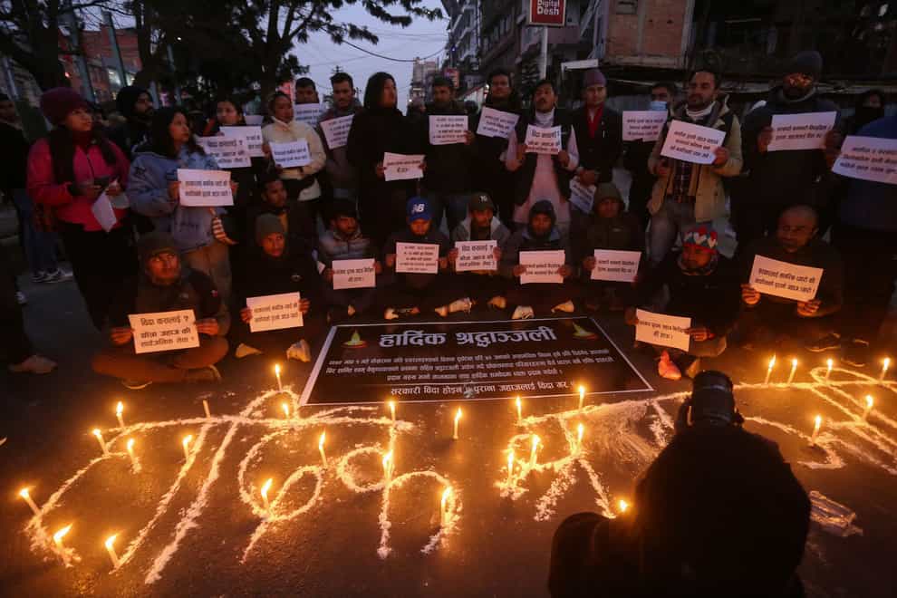 People observe a candlelight vigil in memory of victims of the plane crash (Bikram Rai/AP)