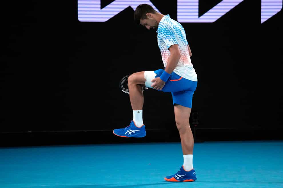 Novak Djokovic stretches out his injured leg (Dita Alangkara/AP)
