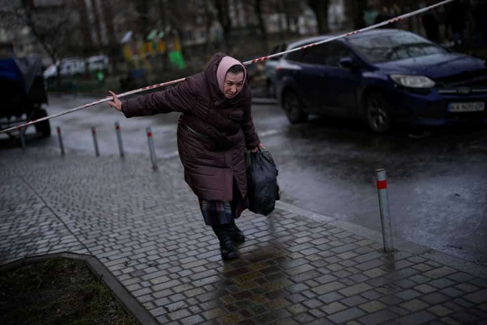A resident leaves the scene where a helicopter crashed into civil infrastructure on Wednesday in Brovary, on the outskirts of Kyiv, Ukraine (Daniel Cole/AP)