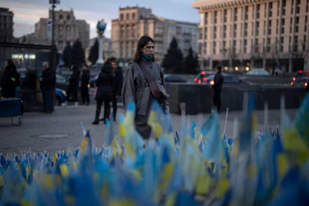 A woman stops to look at Ukrainian flags placed in memory of those killed during the war, near Maidan Square in central Kyiv (Daniel Cole/AP)